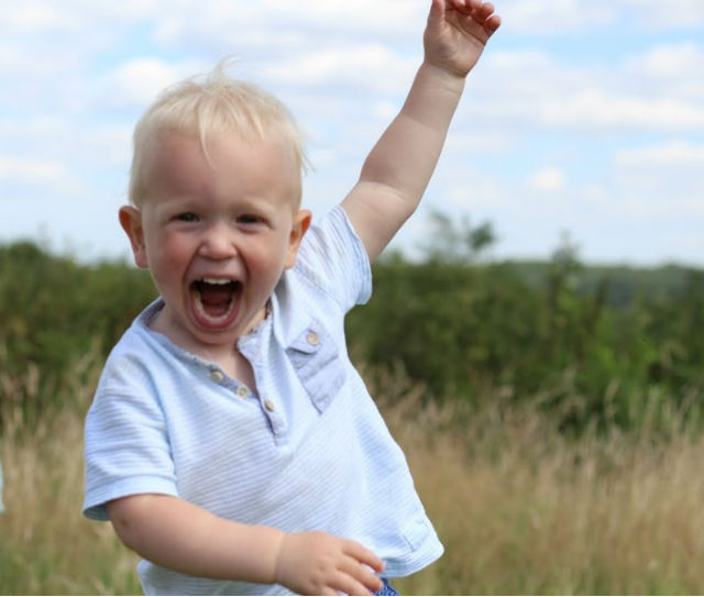 Max running through fields, arms in the air, big smile