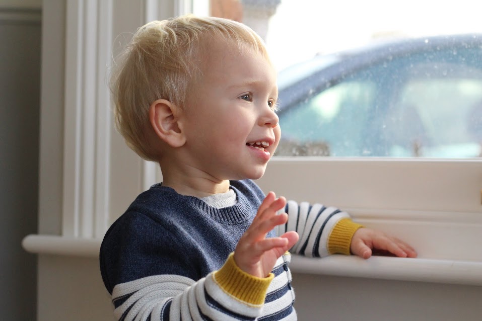 Max standing at the window, waving at the bin men