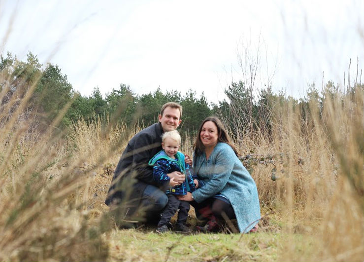 Katy, John and Max, kneeling in front of grass
