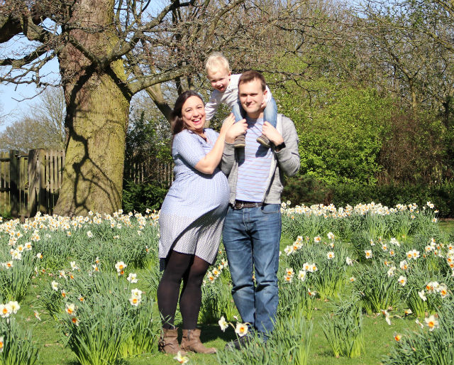 Katy and John standing in daffodils with Max on John's shoulders