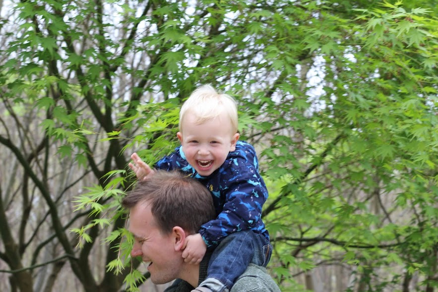 Max riding on Daddy's shoulders, walking through trees, both laughing