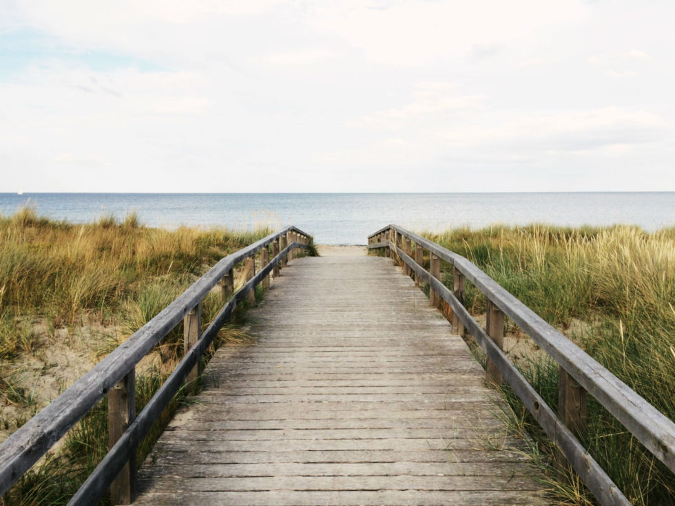 Planning our family holiday to North Norfolk. Wooden boardwalk leading through sand dunes to the sea