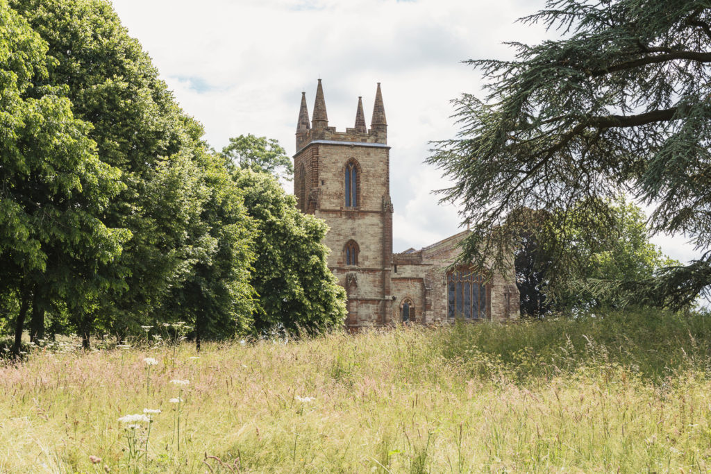 View of the church at Canons Ashby National Trust, with grassy meadow in front