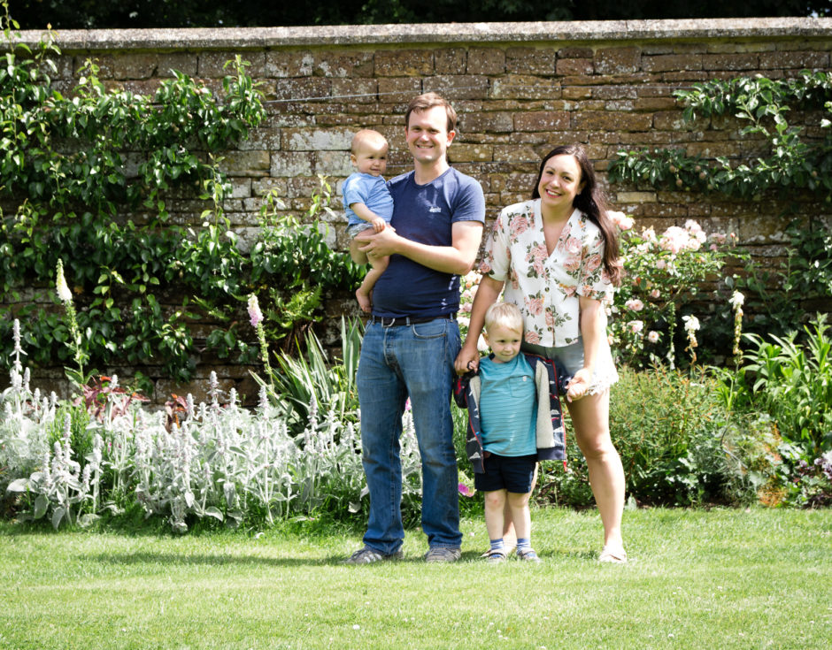 Family portrait in walled garden in front of peach roses