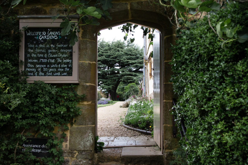 View through stone arched doorway into the ornamental garden at Canons Ashby