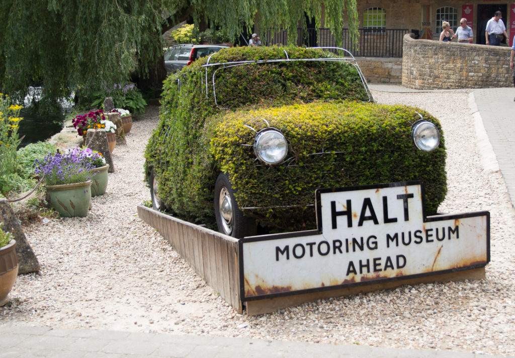 Topiary car with sign reading "Halt, Motoring Museum Ahead" at Bourton on the Water